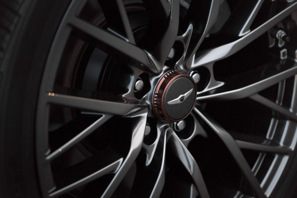 Genesis G80 alloy wheel and center cap closeup detail automotive photography